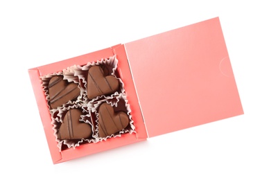 Delicious heart shaped chocolate candies in box isolated on white, top view