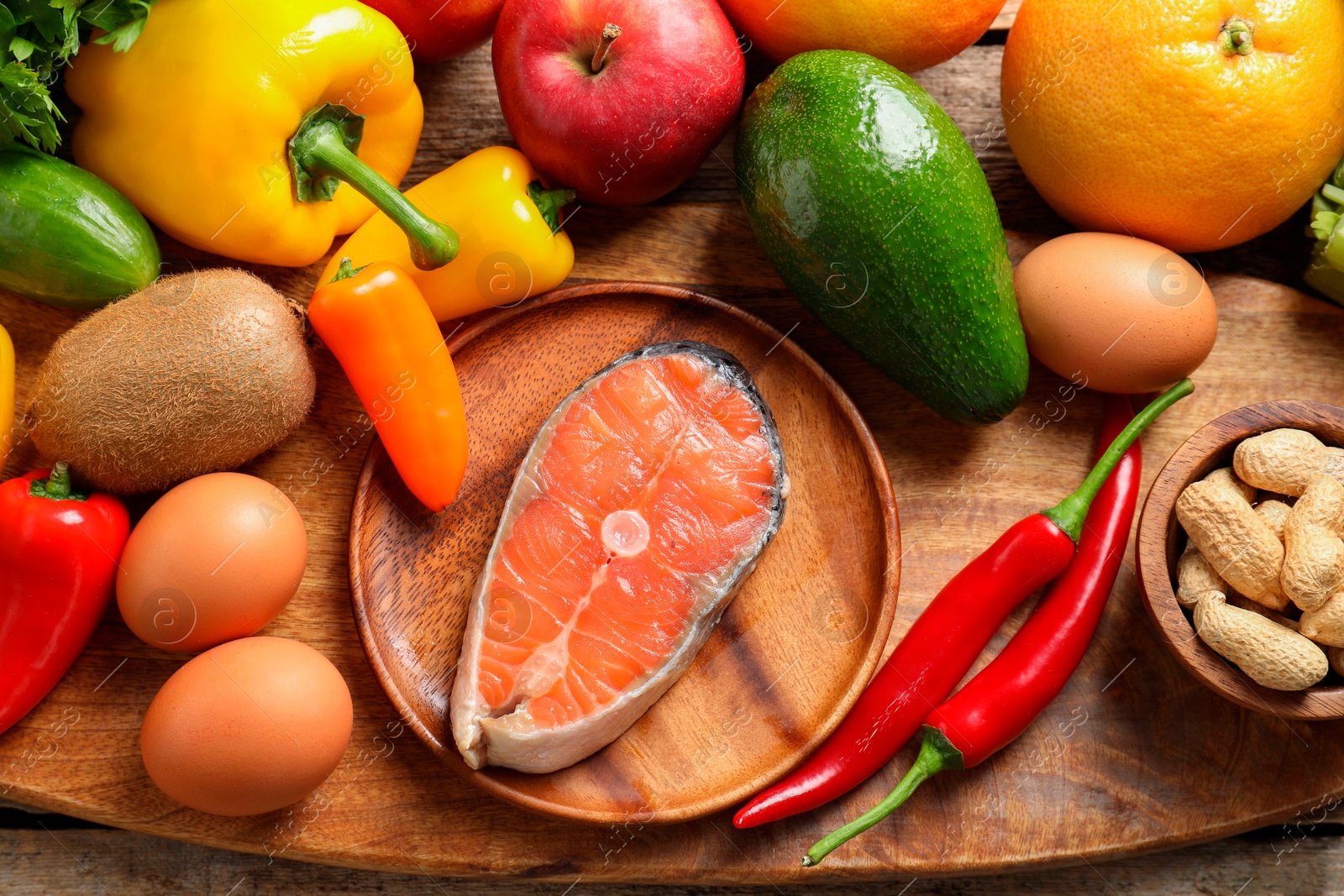 Photo of Healthy meal. Different vegetables and raw salmon on wooden table, flat lay