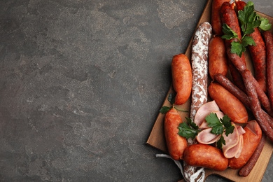 Different tasty sausages on grey table, top view. Space for text