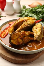 Photo of Tasty fish curry on table, closeup. Indian cuisine