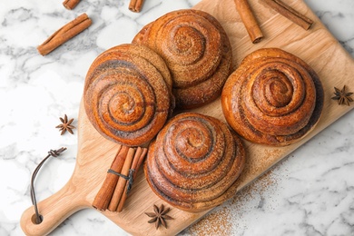 Photo of Flat lay composition with freshly baked cinnamon rolls on marble background