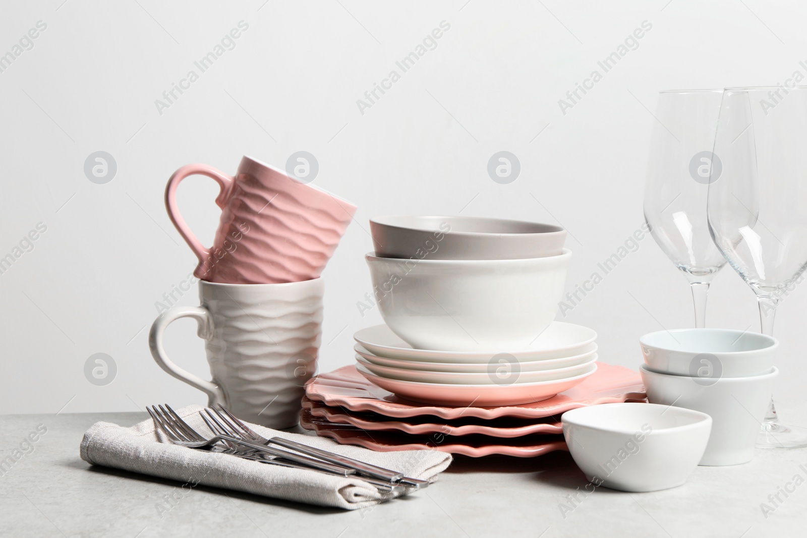 Photo of Beautiful ceramic dishware, cups, glasses and cutlery on light grey table