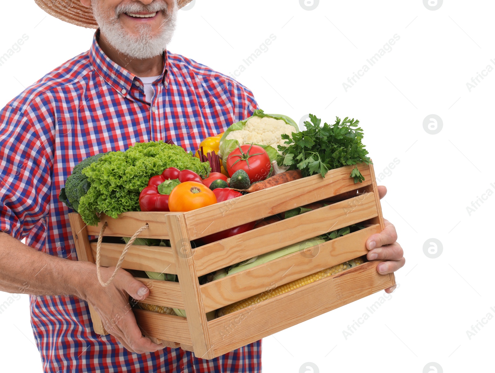 Photo of Harvesting season. Happy farmer holding wooden crate with vegetables on white background, closeup