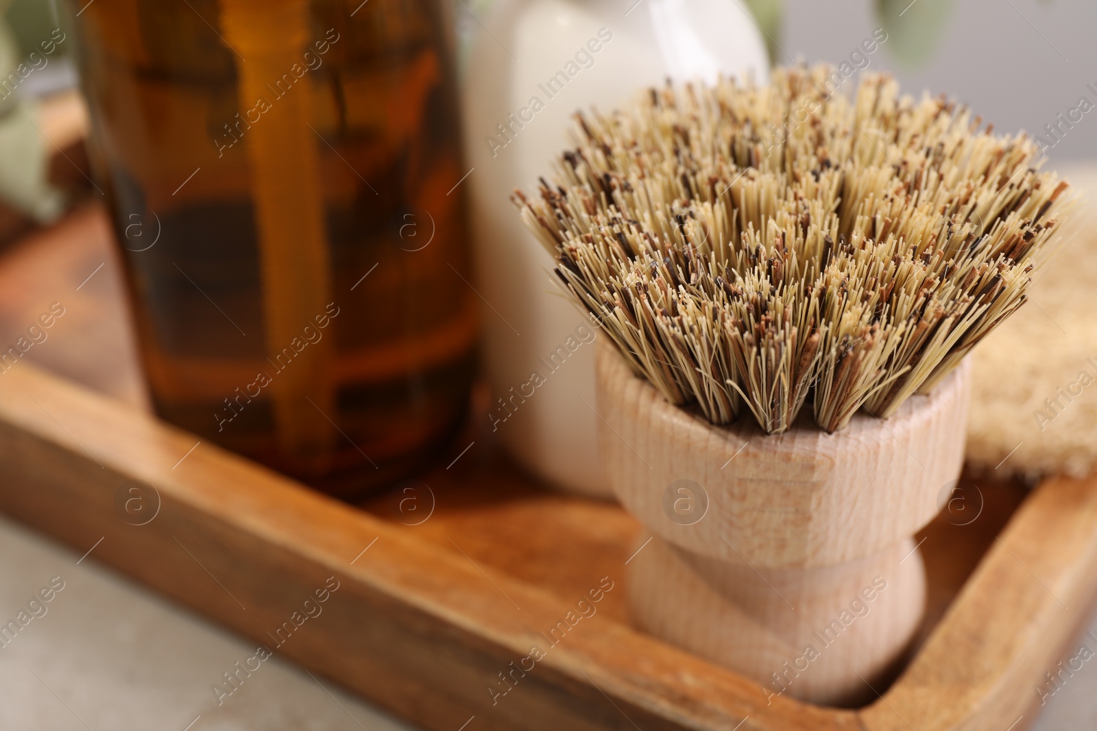 Photo of Cleaning brush and bottles on table, closeup