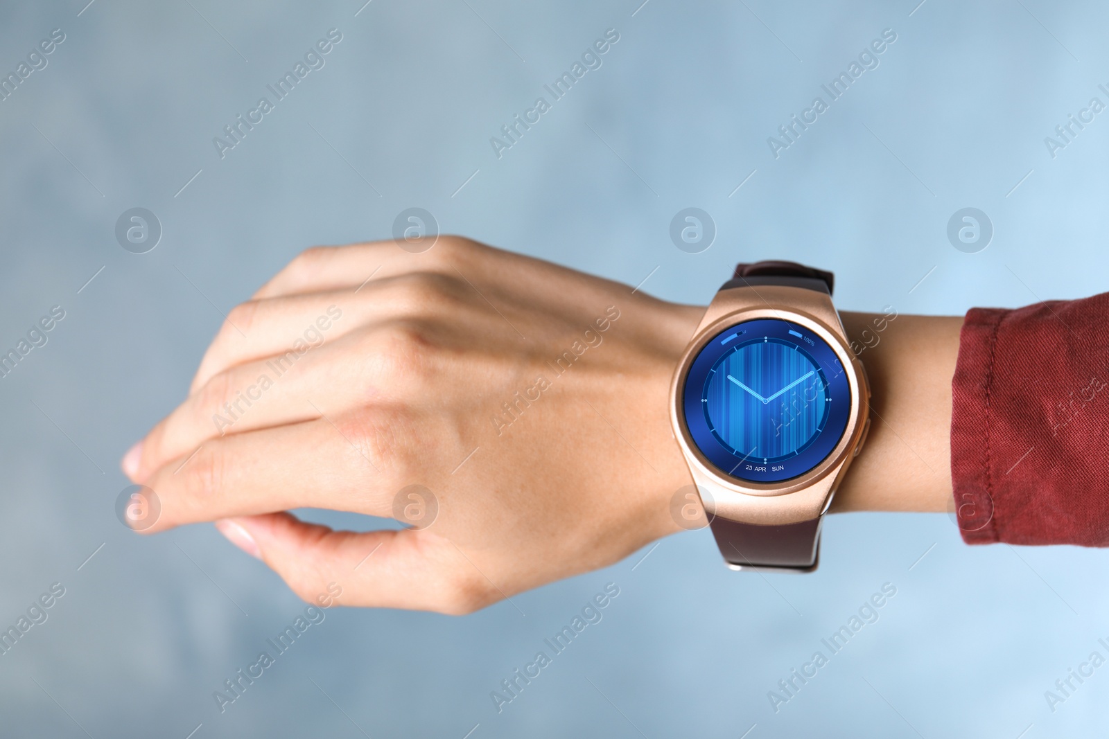 Image of Woman with smart watch displaying analog clock face skin, closeup