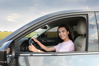 Photo of Beautiful young woman on driver's seat in modern car