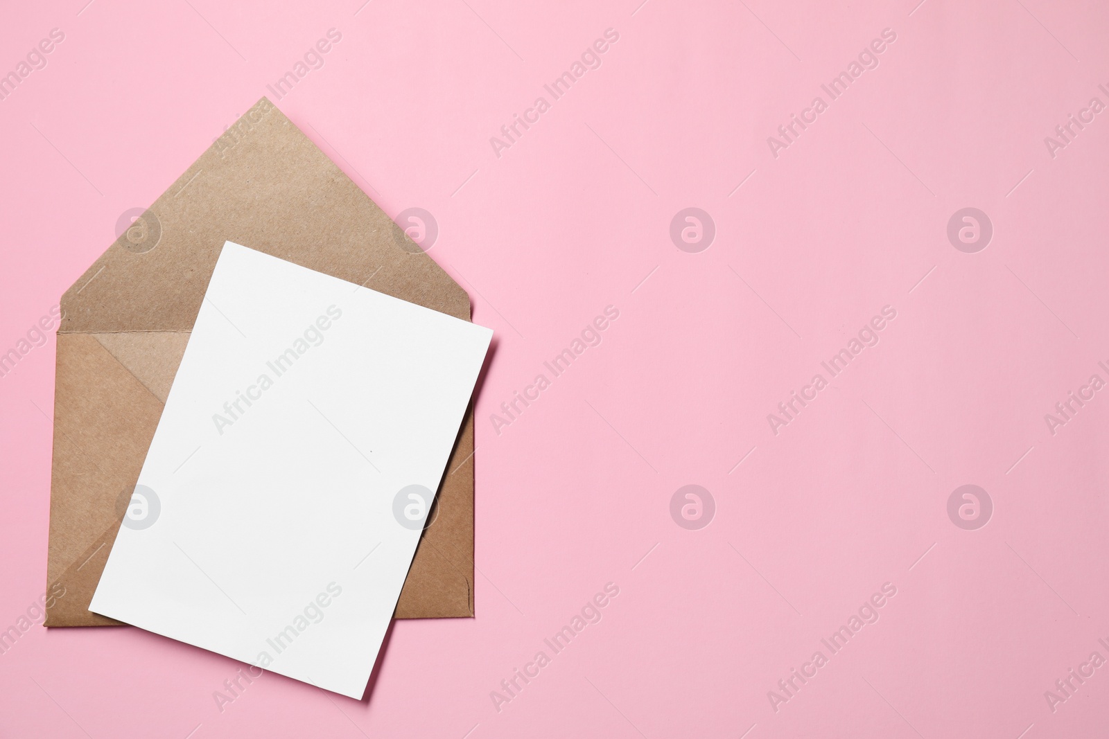 Photo of Letter envelope and card on pink background, top view. Space for text