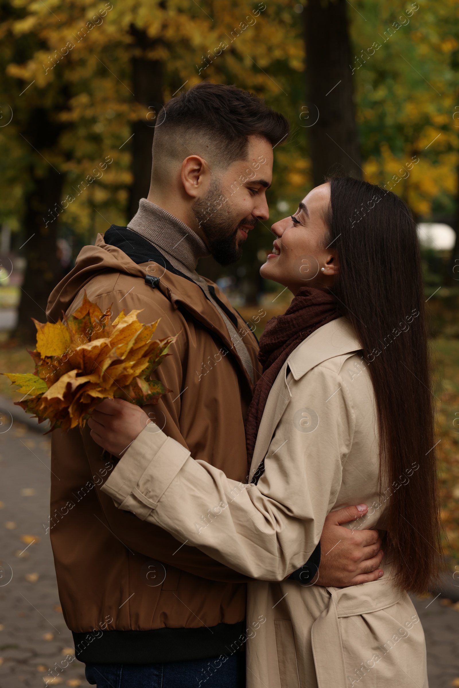 Photo of Happy young couple spending time together in autumn park