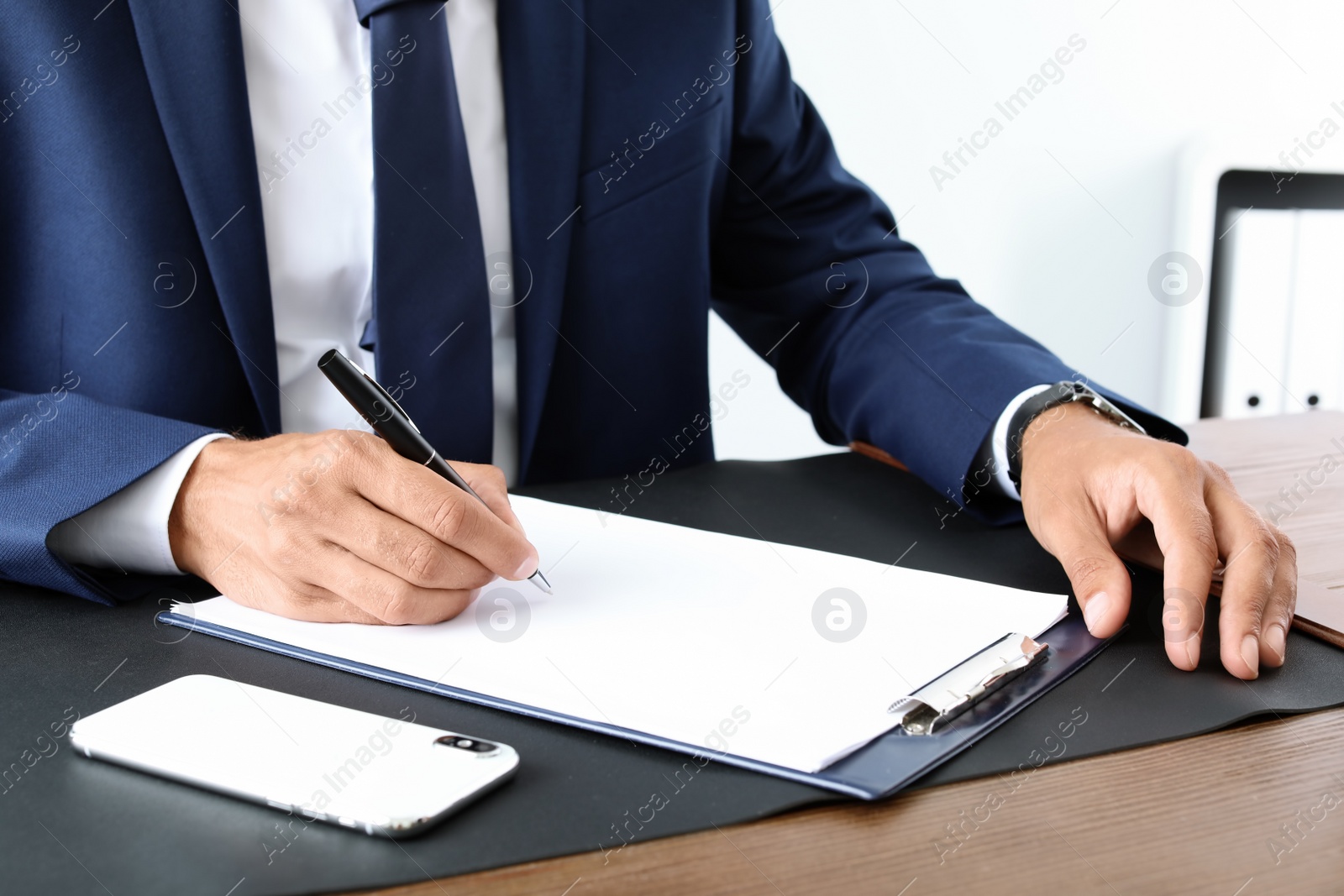 Photo of Male lawyer working with documents at table, closeup. Notary services