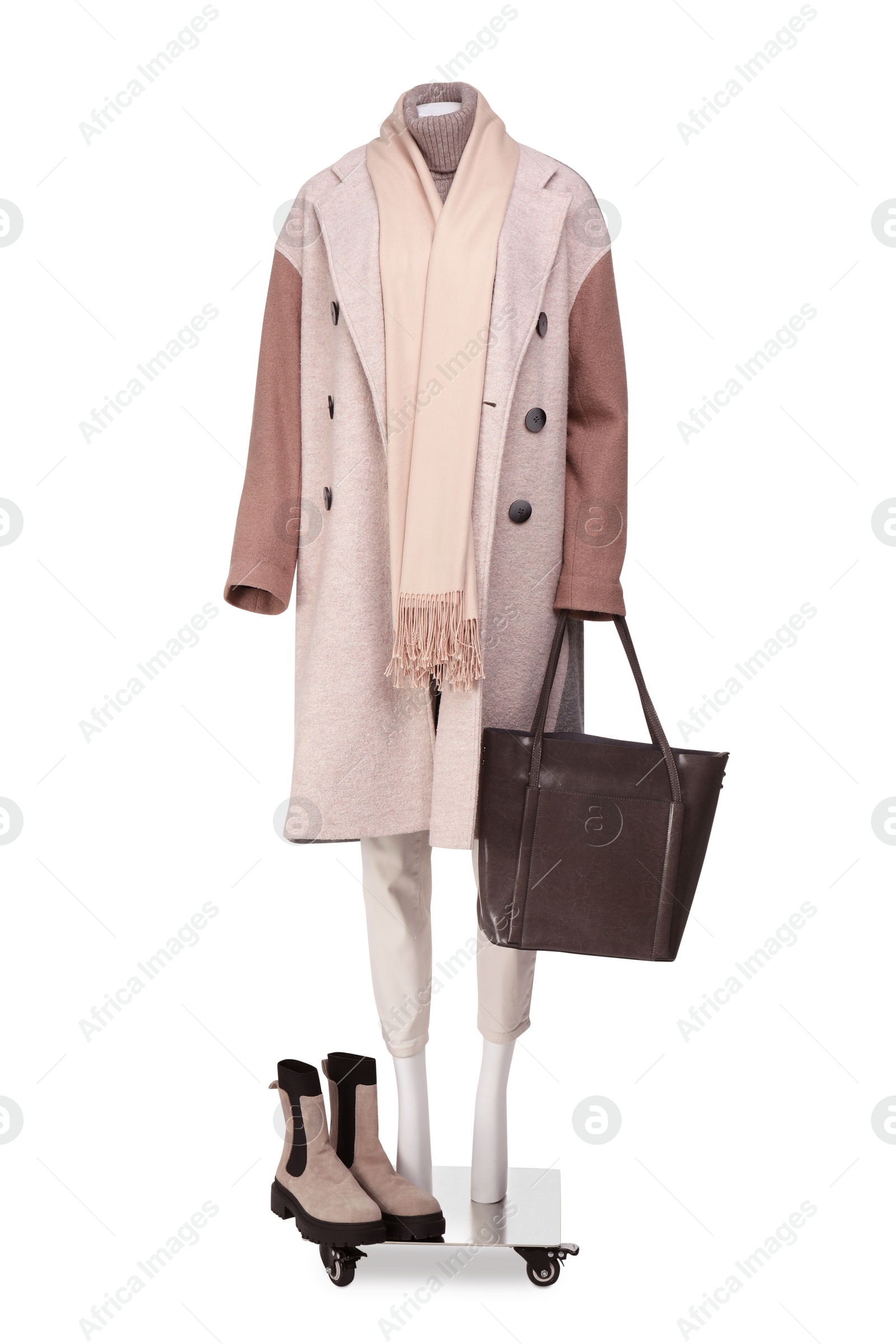 Photo of Female mannequin with accessories and boots dressed in stylish coat, sweater and pants isolated on white