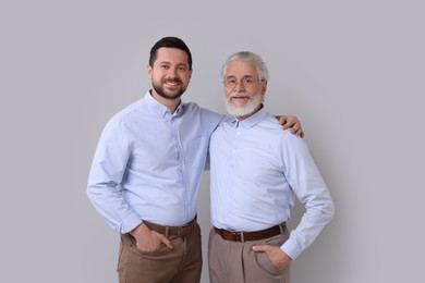 Happy son and his dad on gray background