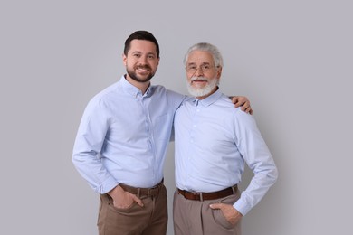 Photo of Happy son and his dad on gray background