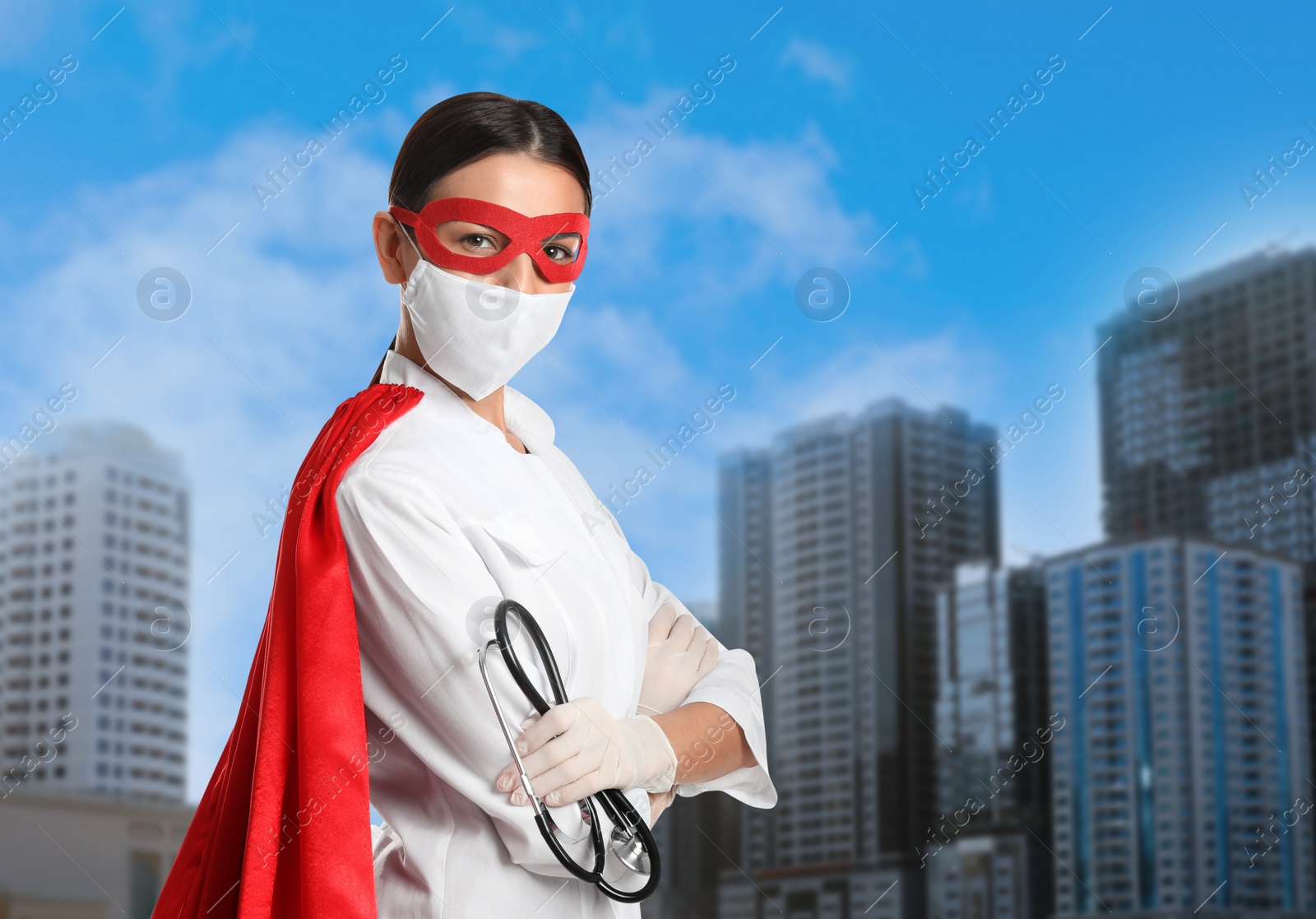 Image of Doctor dressed as superhero on city background. Medical workers fighting with dangerous diseases