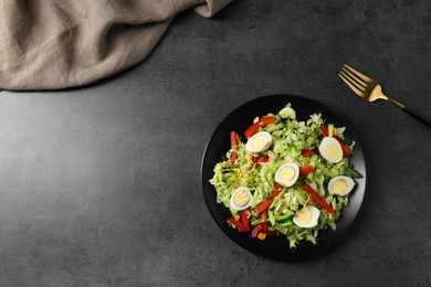 Photo of Delicious salad with Chinese cabbage and quail eggs served on black table, flat lay. Space for text