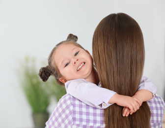 Photo of Young mother with little daughter at home. Space for text