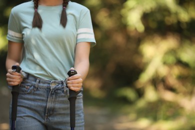 Hiker with trekking poles in forest, closeup