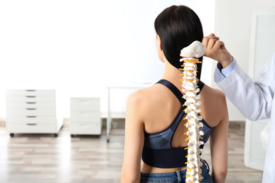 Photo of Young woman visiting orthopedist in medical office. Space for text