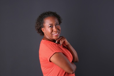 Portrait of happy African-American woman on black background