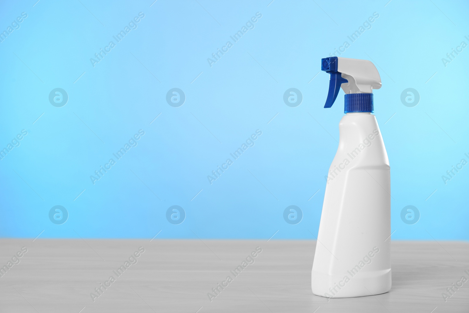 Photo of Bottle of cleaning product on light table. Space for text