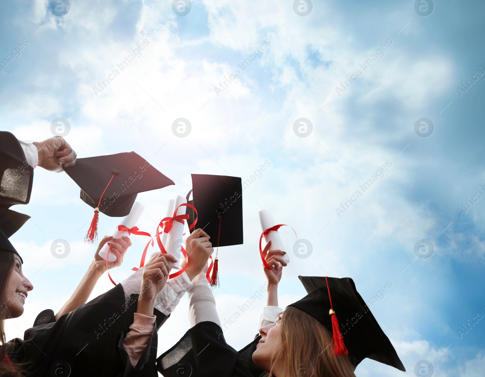Image of Group of students with diplomas outdoors. Graduation ceremony