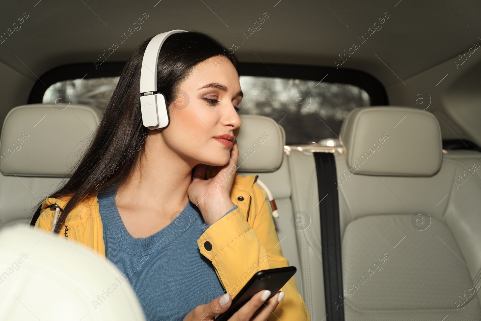 Photo of Young woman listening to audiobook in car