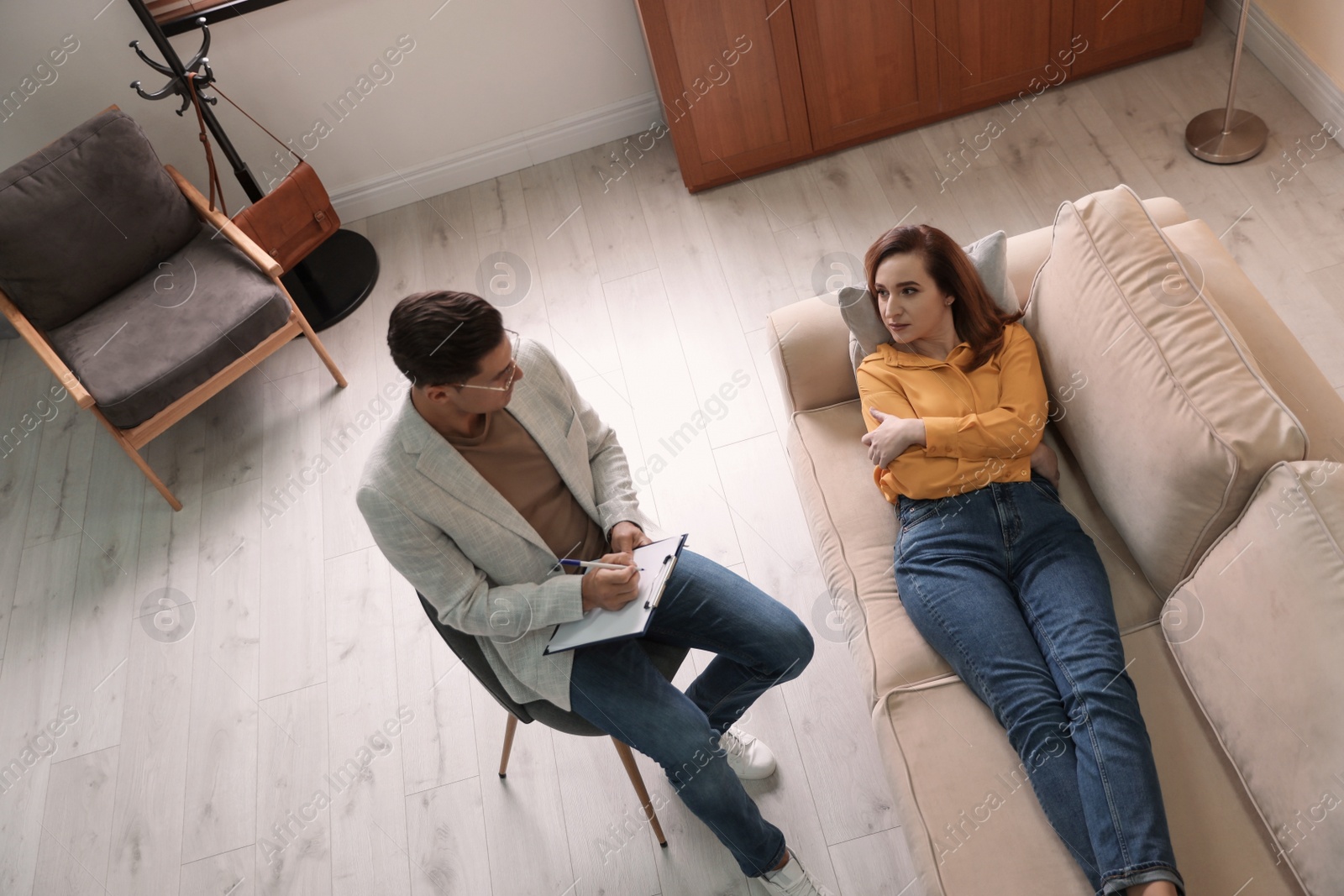 Photo of Professional psychotherapist working with patient in office, above view