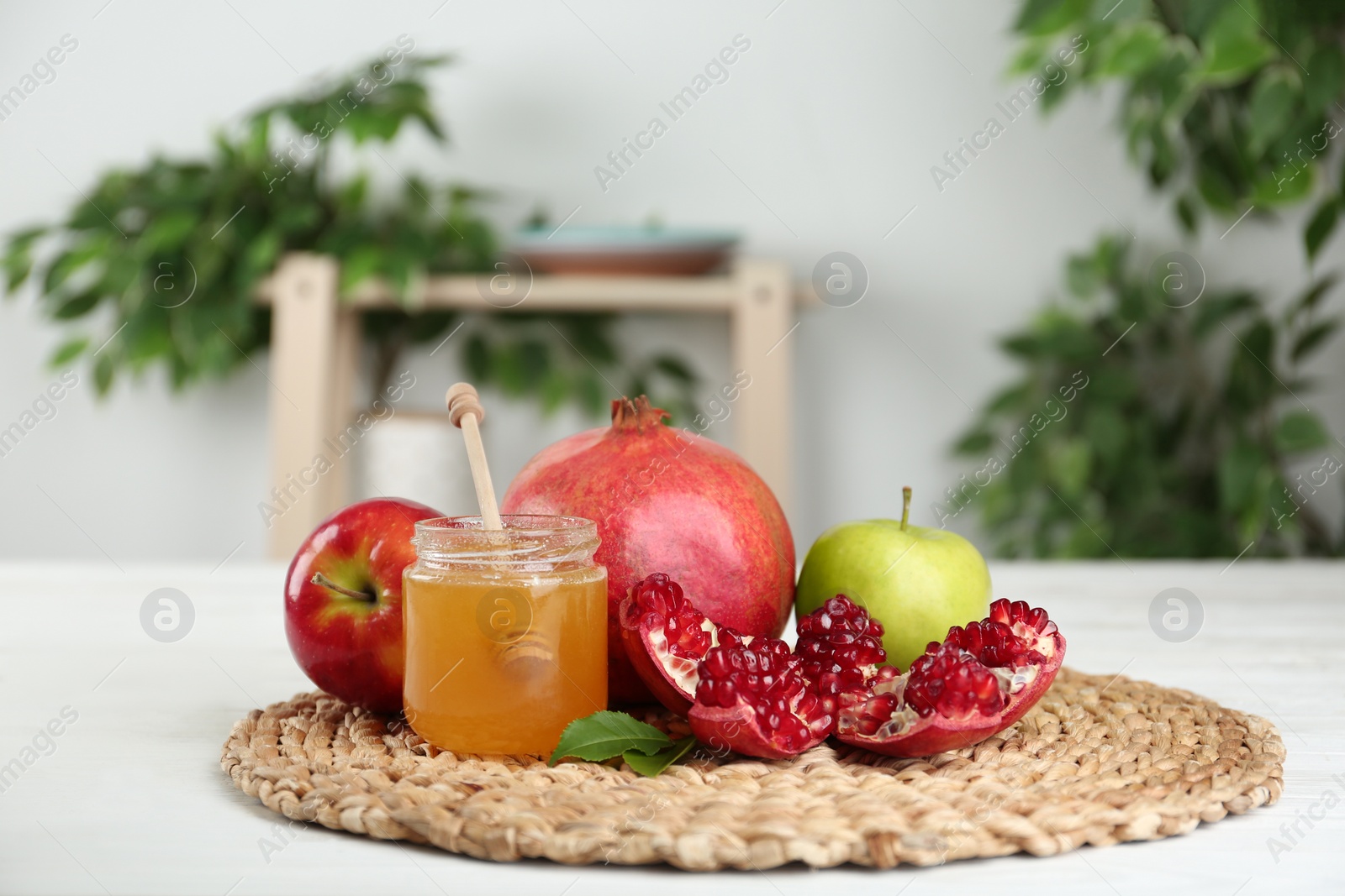 Photo of Honey, apples and pomegranate on white wooden table. Rosh Hashanah holiday