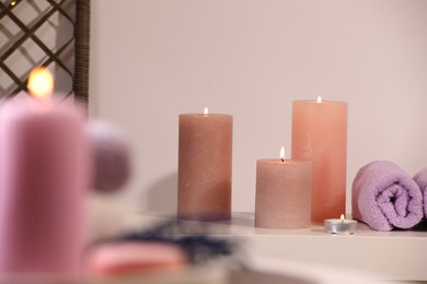 Photo of Spa composition. Burning candles and towels on white table