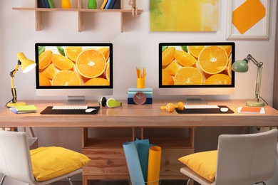 Modern workplace with large desk and computers in room. Stylish interior