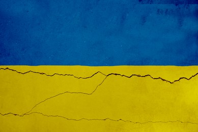 National flag of Ukraine painted on old cracked wall