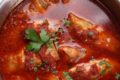 Photo of Delicious stuffed cabbage rolls cooked with homemade tomato sauce in pot, top view