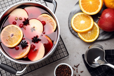 Delicious mulled wine and ingredients on grey table, flat lay