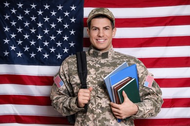 Photo of Cadet with backpack and books against American flag. Military education