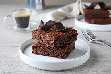 Photo of Delicious chocolate brownies served on white wooden table