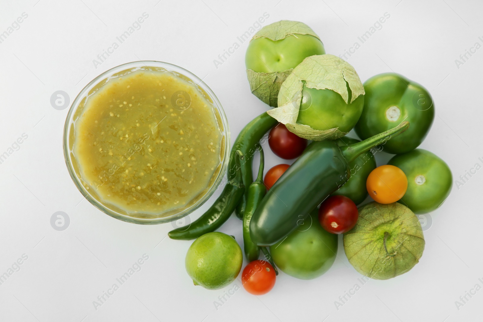 Photo of Bowl with delicious salsa sauce and ingredients on white background, flat lay