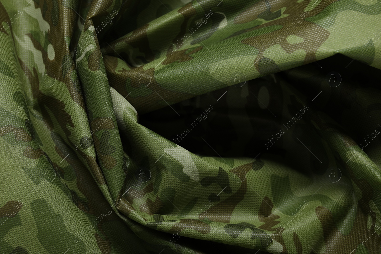 Photo of Texture of crumpled camouflage fabric as background, top view