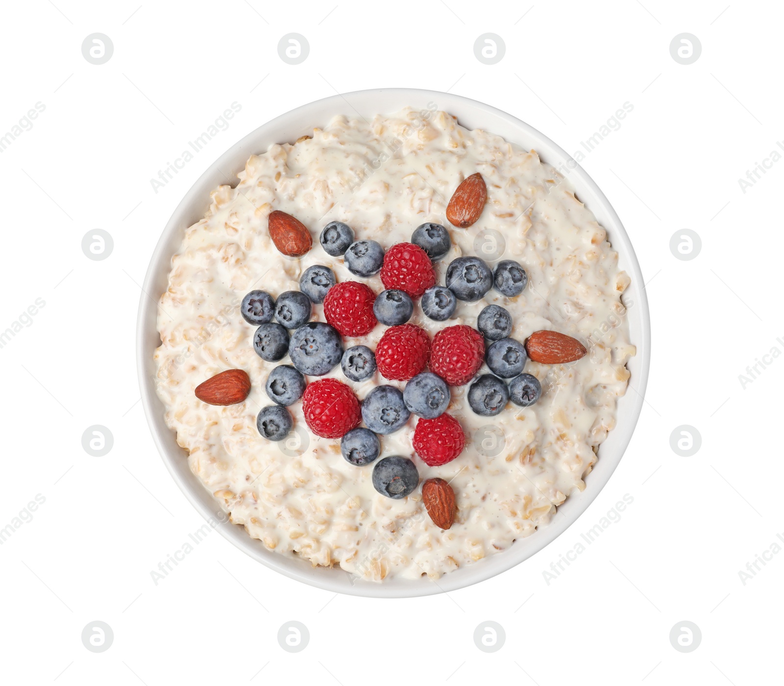 Photo of Tasty boiled oatmeal with berries and almonds in bowl isolated on white, top view