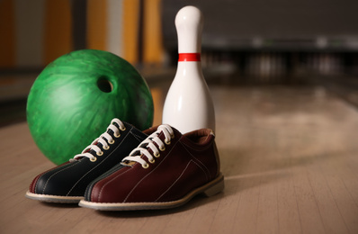 Photo of Pin, shoes and ball on alley in bowling club. Space for text