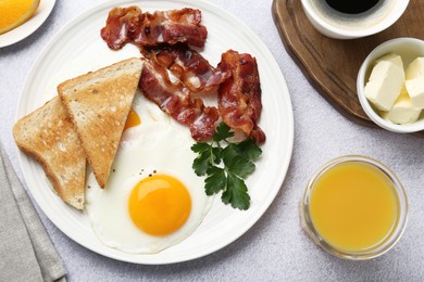 Delicious breakfast with sunny side up egg served on light table, flat lay