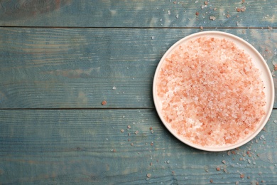 Pink himalayan salt on light blue wooden table, top view. Space for text