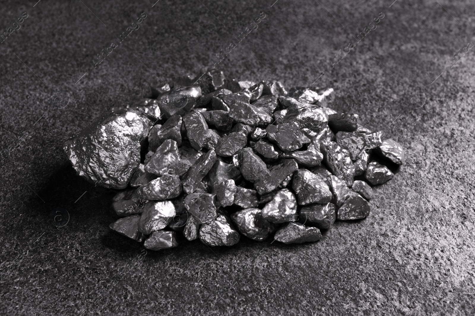 Photo of Pile of silver nuggets on grey textured table