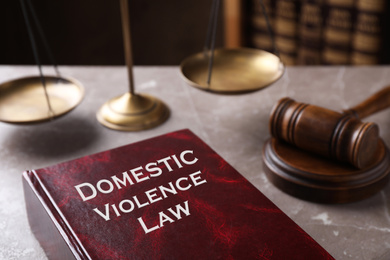 Photo of Domestic violence law and gavel on grey marble table, closeup