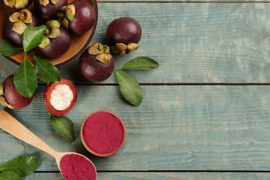 Purple mangosteen powder and fruits on light blue wooden table, flat lay. Space for text