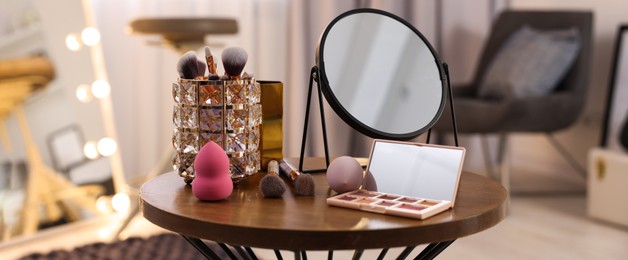 Image of Makeup room. Different beauty products and mirror on wooden table indoors, banner design