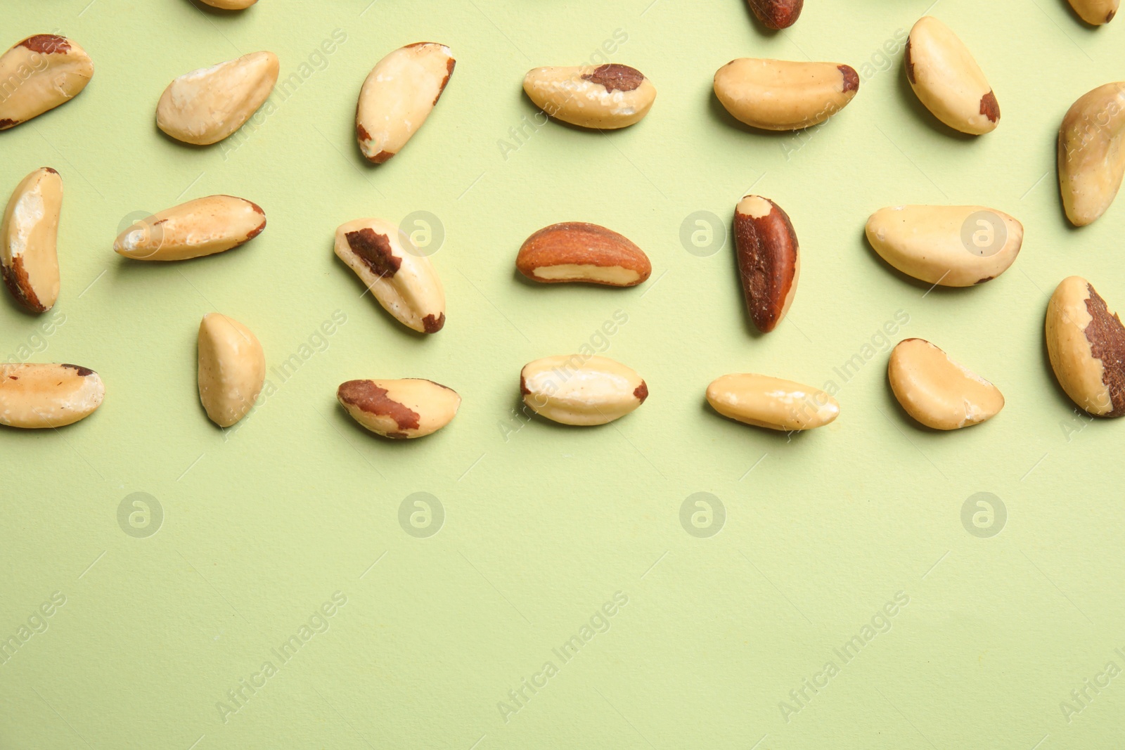 Photo of Flat lay composition with Brazil nuts and space for text on color background