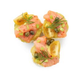Photo of Tasty canapes with salmon, tomatoes, capers and herbs isolated on white, top view