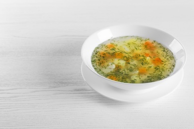 Photo of Bowl of fresh homemade soup to cure flu and space for text on wooden background