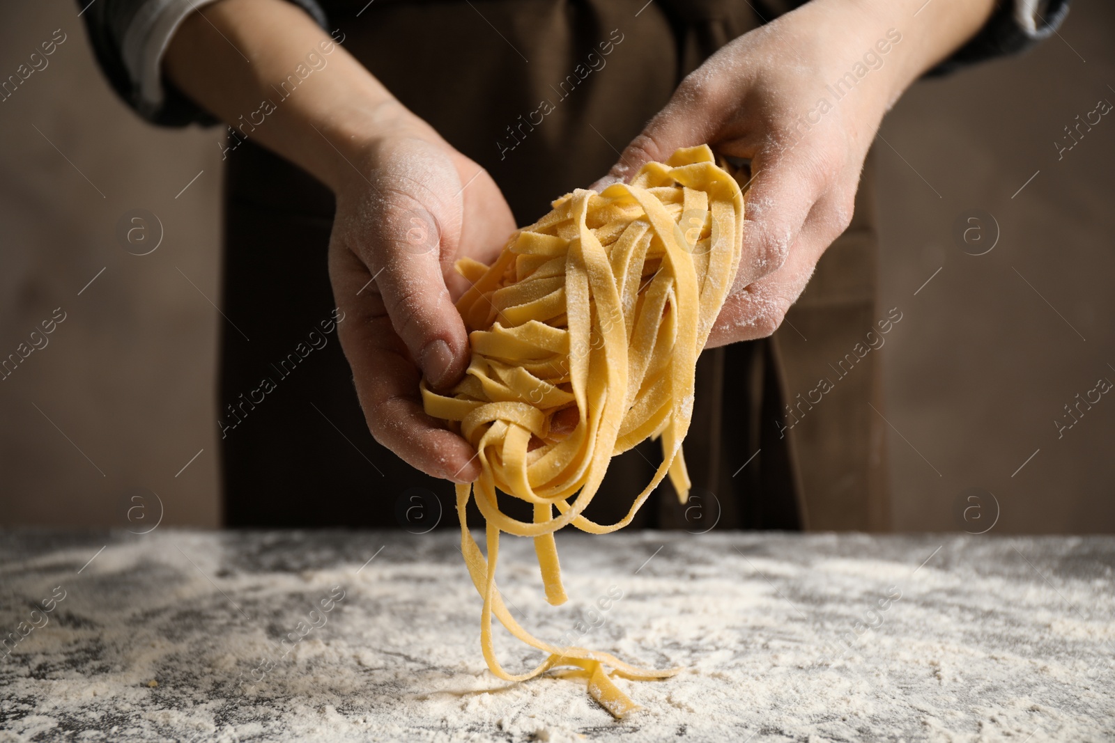 Photo of Woman holding pasta at table, closeup view