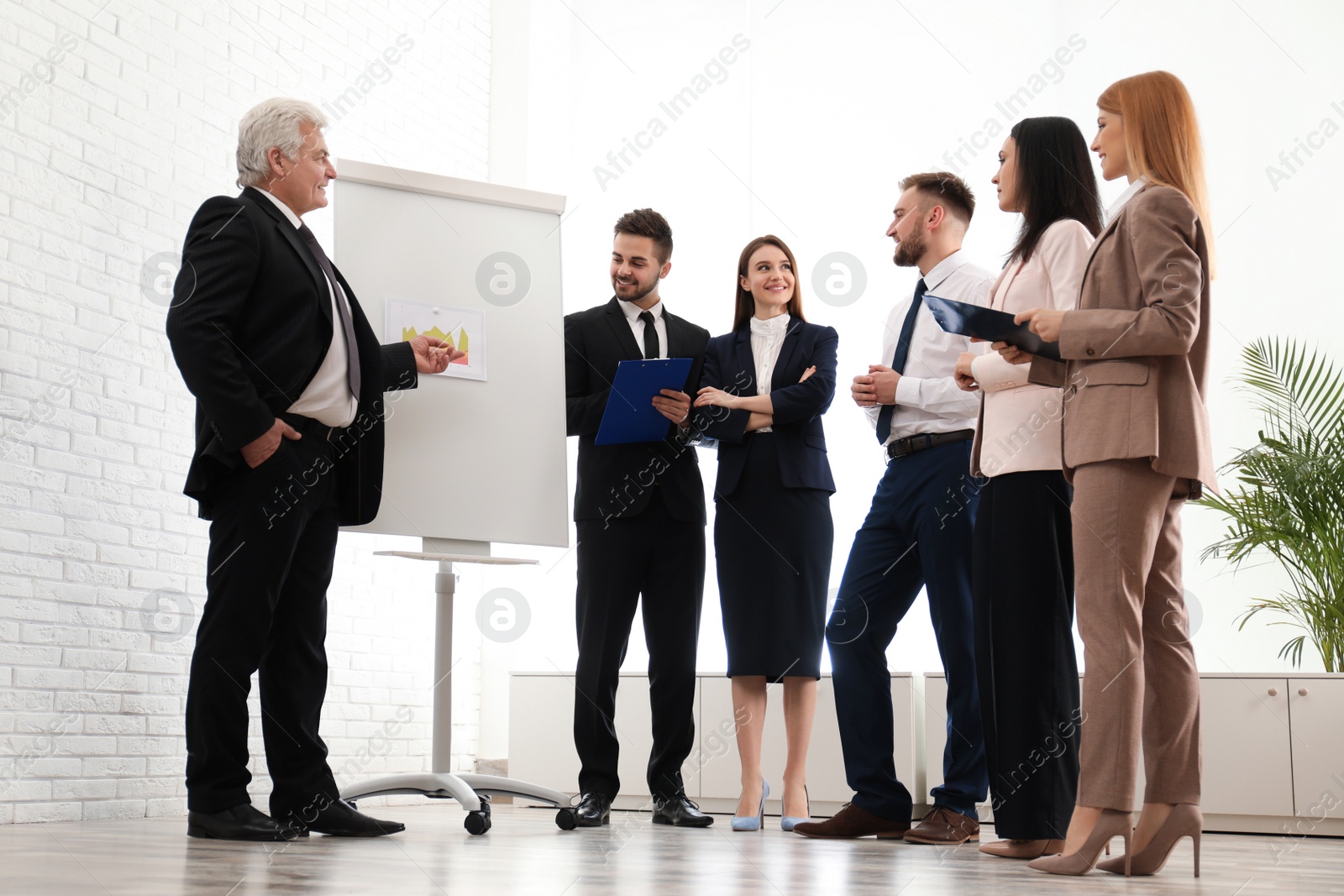 Photo of Senior business trainer working with people in office