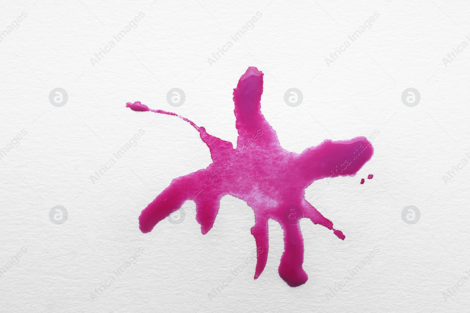 Photo of Blot of pink ink on white background, top view